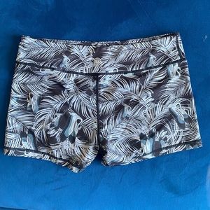 IAB black and white spandex shorts with flamingo and palm tree pattern.